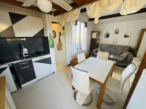 une cuisine et un salon avec une table et des chaises dans l'établissement Studio avec Mezzanine, Terrasse et Parking à 5 min de la Plage - FR-1-723-129, au Cap d'Agde