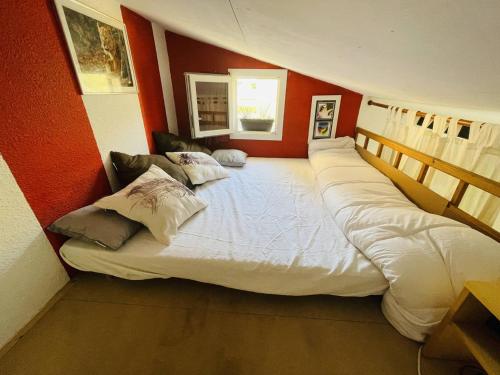 - un grand lit dans une chambre aux murs rouges dans l'établissement Studio avec Mezzanine, Terrasse et Parking à 5 min de la Plage - FR-1-723-129, au Cap d'Agde