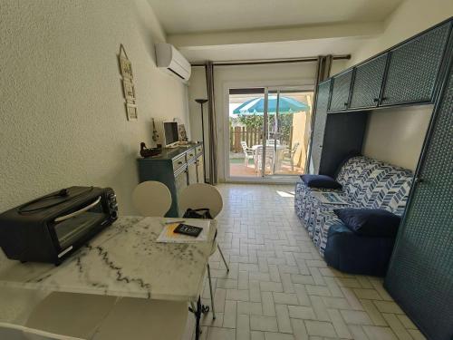- une chambre avec un lit et une table avec un four micro-ondes dans l'établissement Studio alcôve climatisé pour 4 pers. avec parking à 20m de la plage, animaux bienvenus - FR-1-607-184, au Cap d'Agde