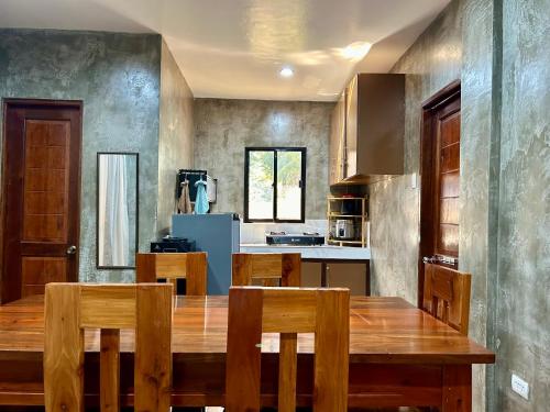 a kitchen with a wooden table and wooden chairs at Bahay Tanglaw San Jose in Puerto Princesa City