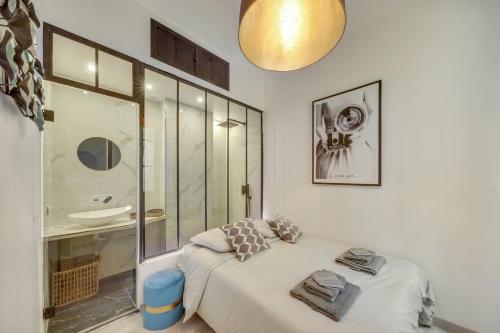 a bedroom with a bed and a sink and a mirror at 133 Suite Charly - Superb apartment in Paris. in Paris