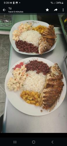 dos platos de comida en una mesa con arroz y frijoles en Esmeralda, en Ojo de Agua