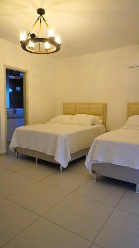sypialnia z 2 łóżkami i żyrandolem w obiekcie Casa de Campo w mieście Santa Cruz de la Sierra
