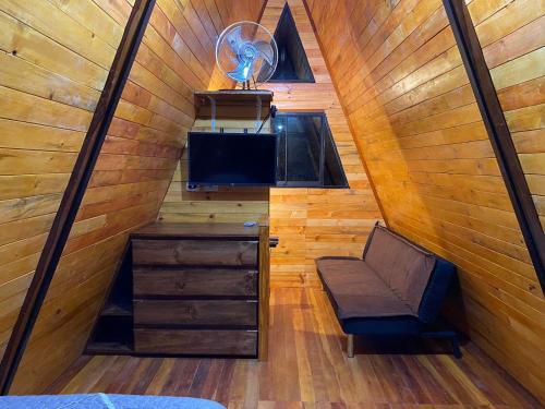 a room with a bed and a chair in a cabin at Estancia Chontabamba - Cabañas, Departamento y Habitaciones in Oxapampa