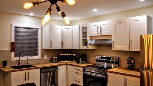 a kitchen with white cabinets and a ceiling fan at Chalet Labonté in Mont-Tremblant
