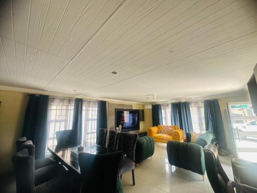 a living room with a couch and a table and chairs at MBT Guesthouses in Ga-Mothiba