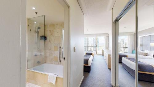 a bathroom with a tub and a shower in a room at Cosy Studio with Stunning Ocean Views DUPLICATE in Gold Coast