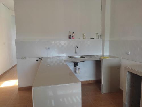 uma cozinha branca com um lavatório e uma lareira em Hospedaje Camila em Pucallpa