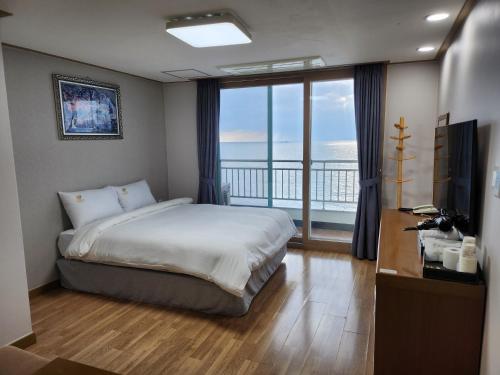 Mud Beach Hotel في بوريونغ: غرفة نوم مع سرير وإطلالة على المحيط