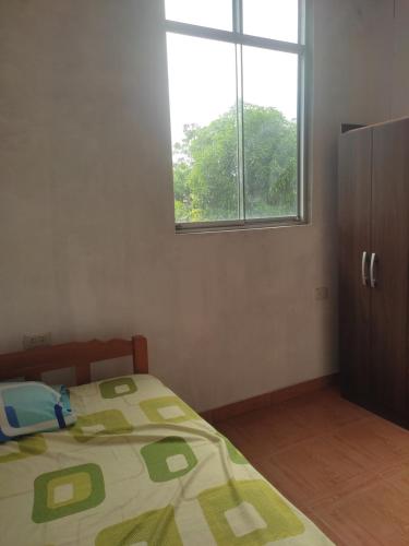 1 dormitorio con cama y ventana en Hospedaje Camila, en Pucallpa