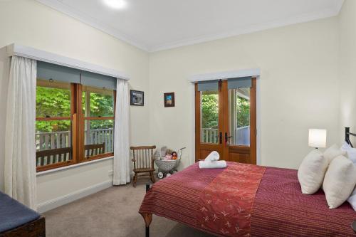 ein Schlafzimmer mit einem Bett und einem Balkon in der Unterkunft 'Rosalba' The Old Dairy Farm 3-Bed Cottage in Burrawang