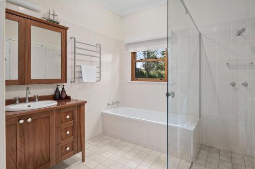 ein Badezimmer mit einer Dusche, einer Badewanne und einem Waschbecken in der Unterkunft 'Rosalba' The Old Dairy Farm 3-Bed Cottage in Burrawang