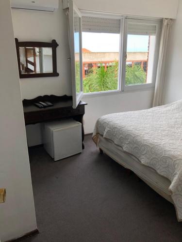 a bedroom with a bed and a mirror and a window at Hotel Gaudí in Punta del Este