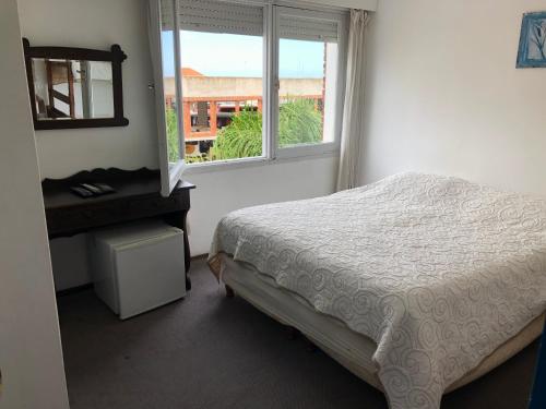 a bedroom with a bed and a window at Hotel Gaudí in Punta del Este