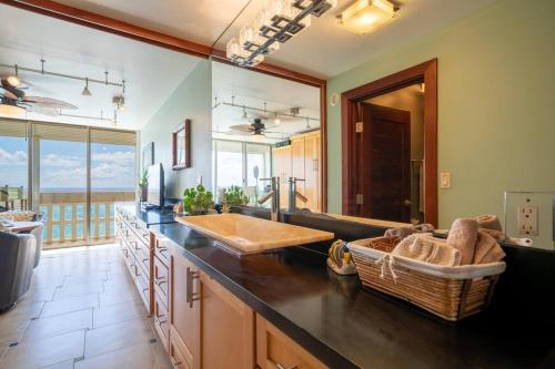 a kitchen with a counter with a sink and a couch at Beachfront Condo in Paradise in Waianae