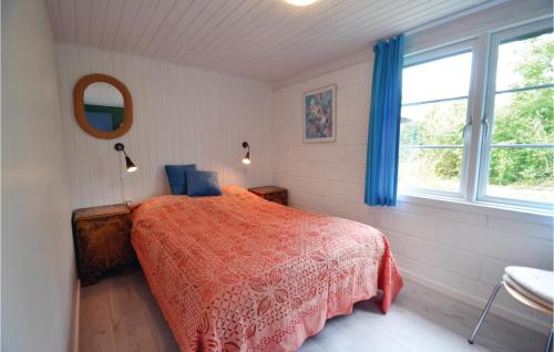 a bedroom with a red bed and a window at Nice Home In Vinderup With 3 Bedrooms And Wifi in Vinderup