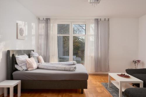 a living room with a couch and a window at Schönbrunn Palace Apartments FREE Parking and 24h Check-In in Vienna