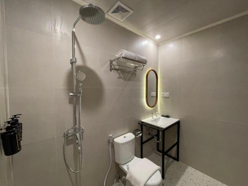 a bathroom with a shower and a toilet and a sink at Azana Essence Sanggabuana Bogor in Kamparganya