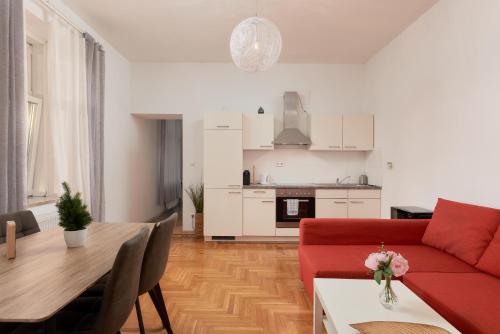 a living room with a red couch and a table at Schönbrunn Palace Apartments FREE Parking and 24h Check-In in Vienna