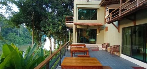 a balcony of a house with chairs and a table at Naura Roomstay in Kuala Tahan