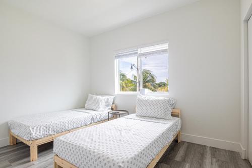 Dos camas en una habitación con ventana. en Comfy 3 Bed 2 Bath Apt W Free Parki, en Hallandale Beach