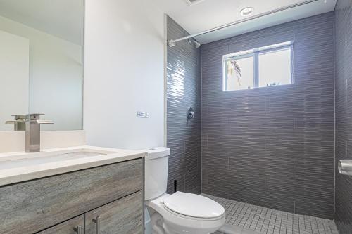 La salle de bains est pourvue de toilettes, d'un lavabo et d'une douche. dans l'établissement Comfy 3 Bed 2 Bath Apt W Free Parki, à Hallandale Beach
