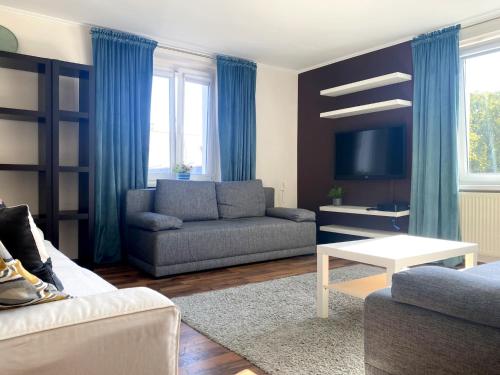 a living room with a couch and a tv at Helska Space by Grand Apartments in Sopot