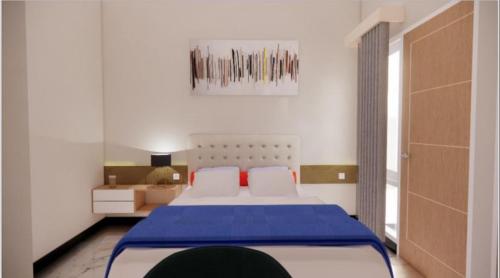 Demangan的住宿－Sumarsi Homestay Mitra RedDoorz，一间卧室配有一张带蓝色毯子的大床