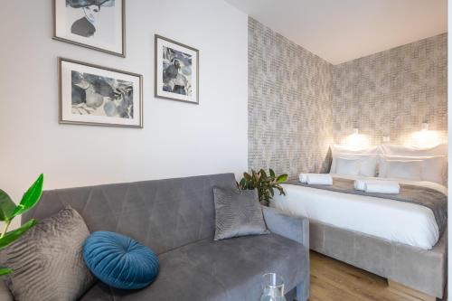 a living room with a couch and a bed at Jaworska 4 Apartments Wrocław in Wrocław