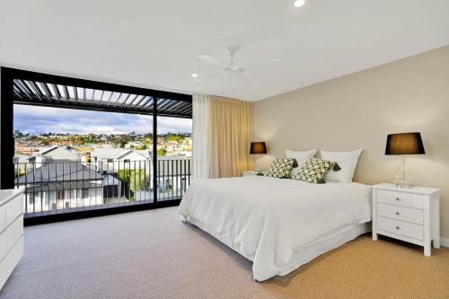 a bedroom with a white bed and a large window at Stunning Apartment in the CBD with Parking & WiFi in Launceston