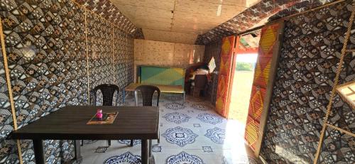 Pokój ze stołem i krzesłami oraz pokój ze stołem i ścianą w obiekcie Road to Haven chandani w mieście Dholovira