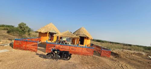 a motorcycle parked in front of a house on a hill at Road to Haven chandani in Dholovira