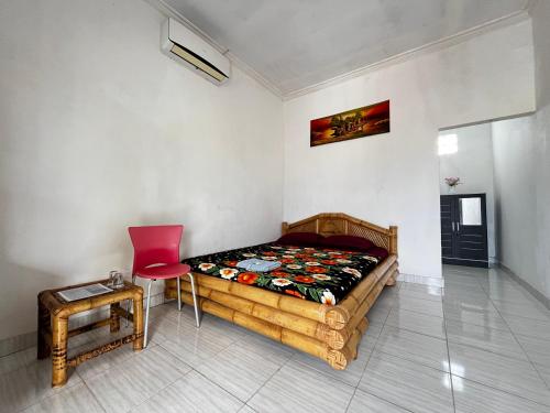a bedroom with a bed and a table and a chair at Alan's Homestay in Kuripan