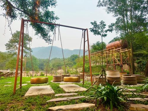 a swing set in a field with a playground at CĂN KITE- CÁNH DIỀU ( MOON VLLA SÓC SƠNI in Hanoi