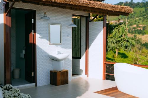a bathroom with a tub and a sink and a window at Oasis Yurt Villa @ Doi Lan - โอเอซิส เยิร์ต วิลล่า @ ดอยล้าน in Ban Huai Khai