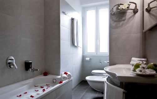 a bathroom with a tub and a toilet and a sink at Garibaldi Palace in Milan