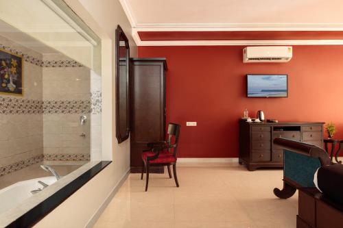 a bathroom with a tub and a sink and a desk at Wild Berry Resort Agonda in Canacona