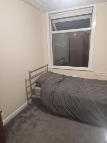 a bed in a room with a window at Cozy Bedroom in Spacious House Manchester in Rochdale