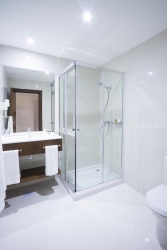 a bathroom with a glass shower and a sink at Fiesta Residences Boutique Hotel and Serviced Apartments. in Accra