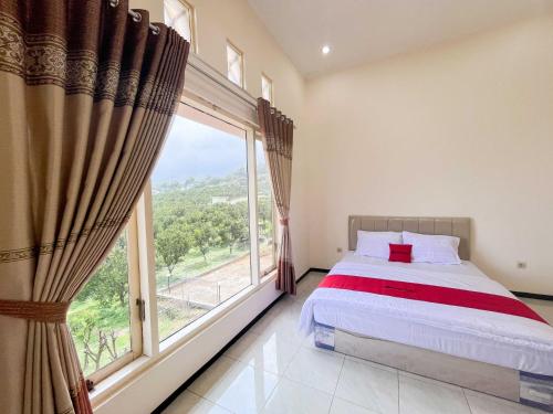 a bedroom with a bed and a large window at Reddoorz Near BNS 2 in Tlekung