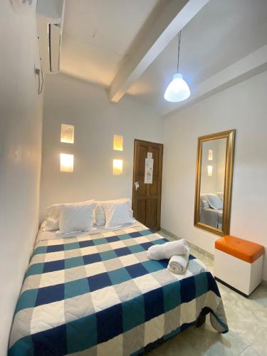 a bedroom with a blue and white checkered bed at Patio de Getsemani in Cartagena de Indias