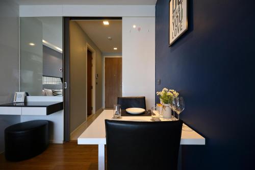 une salle à manger avec une table et un mur bleu dans l'établissement Luxury Modern Garden View Apartment, à Chiang Mai
