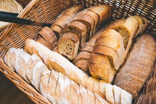 a basket filled with lots of different types of bread at Hotel Zenit Budapest Palace in Budapest