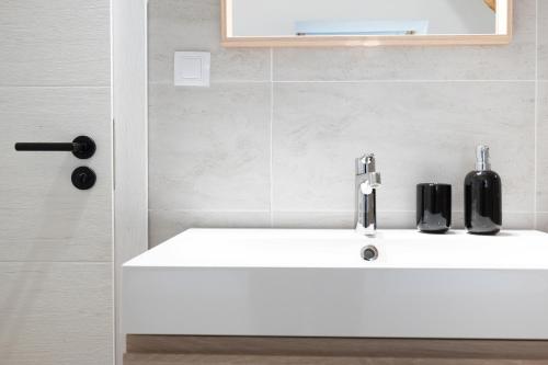 a bathroom sink with two black soap dispensers on it at U Zlaté hvězdy Zeibich in Litoměřice