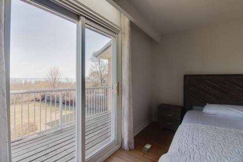 a bedroom with a bed and a large sliding glass door at Lake View House, 30 minutes to Downtown Toronto in Toronto