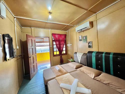 a bedroom with a bed and a door and a window at Perhentian Sri Tanjung , Kampung Nelayan Pulau Perhentian in Perhentian Island