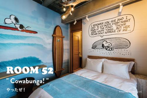 um quarto com uma cama e uma prancha de surf na parede em ピーナッツホテル/PEANUTS HOTEL em Kobe