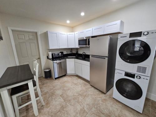 a kitchen with white cabinets and a washer and dryer at 1-Bedroom Apt-9W1 20-Minuite To Downtown Boston in Boston