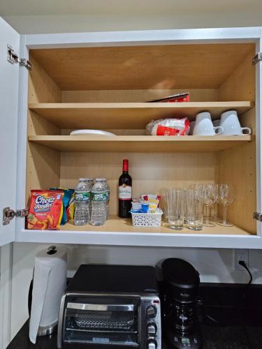 a kitchen pantry with a bottle of wine and food at 1-Bedroom Apt-9W1 20-Minuite To Downtown Boston in Boston