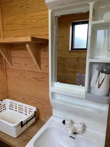 W łazience znajduje się umywalka i lustro. w obiekcie Boiboi Camp site Surrounded by Japanese Nature w mieście Taketa